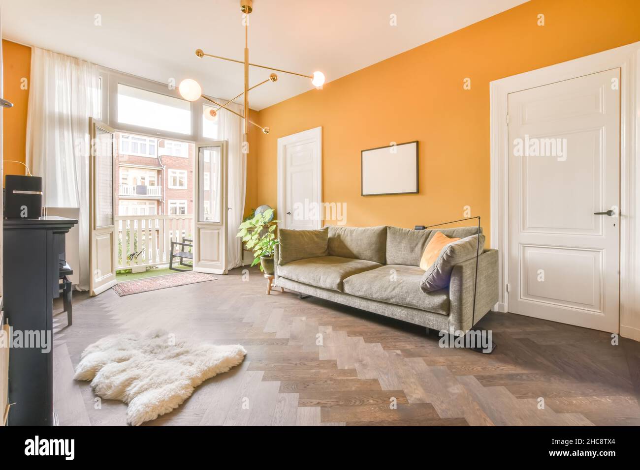 Cozy living room with gray sofa and orange wall Stock Photo - Alamy