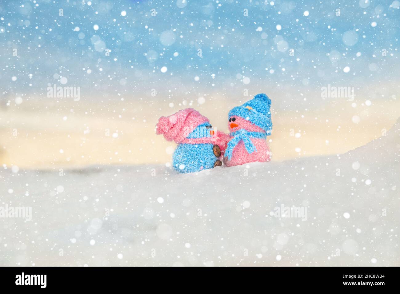 Cute homemade snowmen with scarves and hats on the mountain. Winter's Tale. Greeting card with copy space. Winter background. Stock Photo