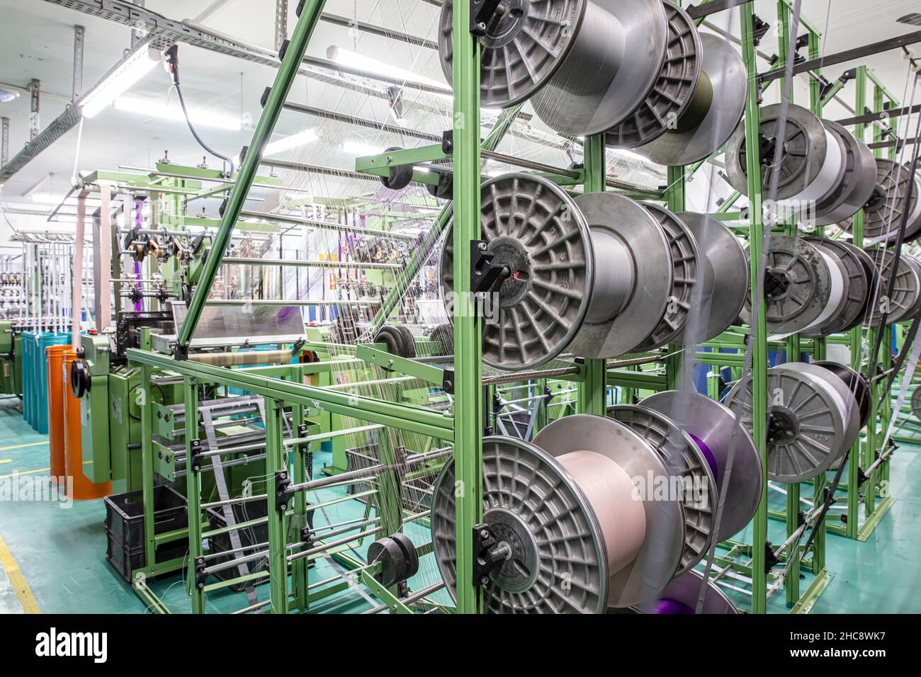 Narrow warp beams on the loom. Textile industry. Spinning spool on a spinning machine in a