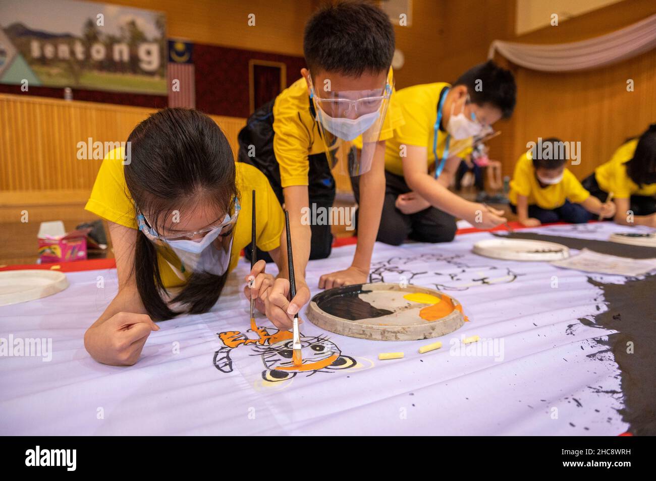 211226) -- BENTONG, Dec. 26, 2021 (Xinhua) -- Students work on a tiger-themed  Chinese New Year picture in Bentong of Pahang state, Malaysia, Dec. 26,  2021. Local Chinese group organized the event