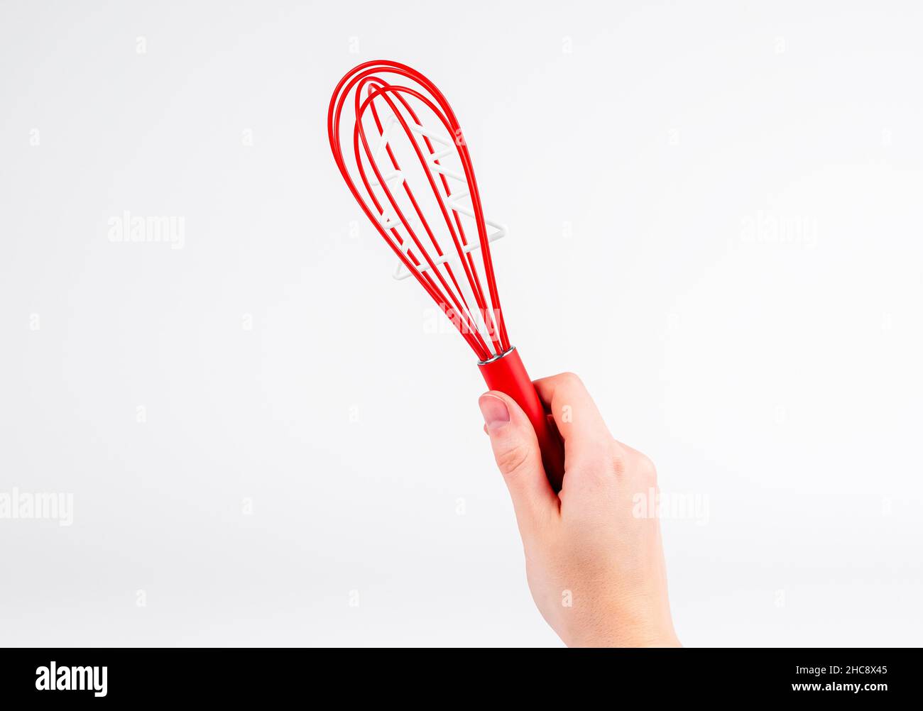 https://c8.alamy.com/comp/2HC8X45/red-whisk-tool-in-hand-over-white-background-whipping-beater-for-holidays-with-christas-tree-inside-2HC8X45.jpg