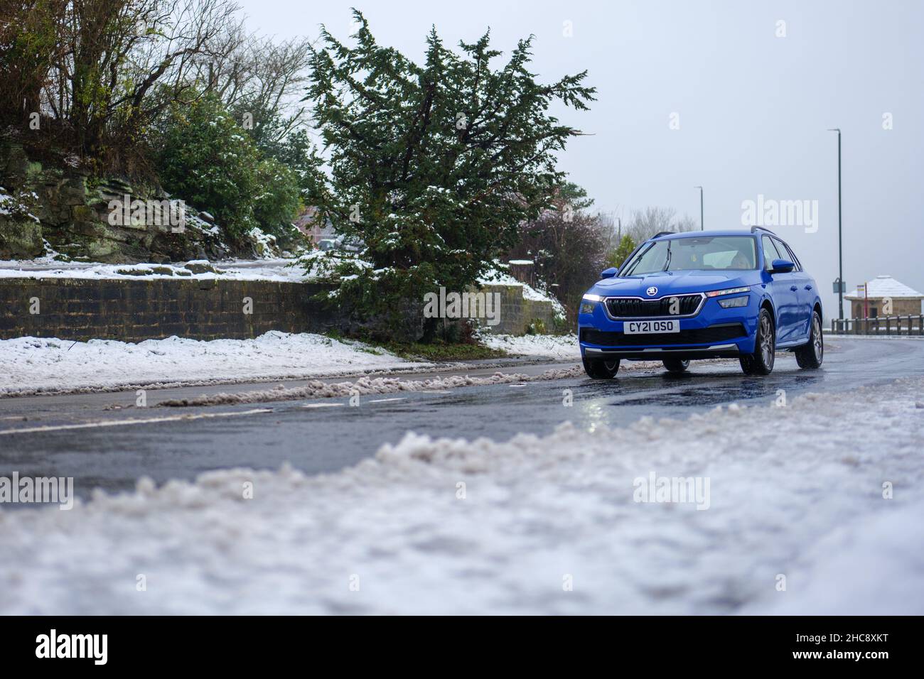 Car drivers face icy road conditions with snow and wintry fog making