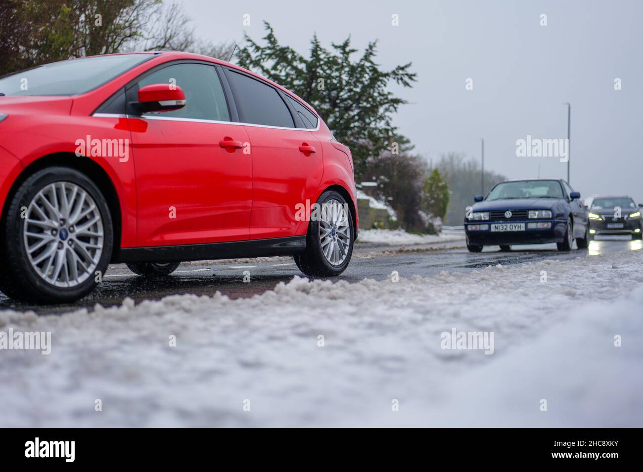 Car drivers face icy road conditions with snow and wintry fog making