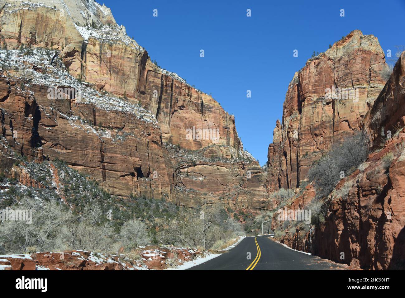 Large format panoramic landscape of the snow dusted colorful cliffs surrounding the road through Zion National Park, Utah, USA. Stock Photo