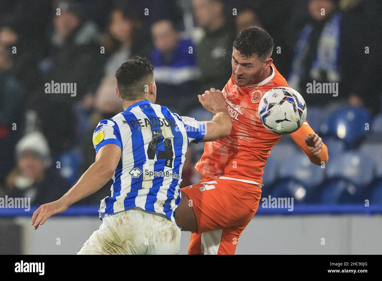 Gary Madine #14 of Blackpool wins the ball from Matty Pearson #4 of Huddersfield Town Stock Photo