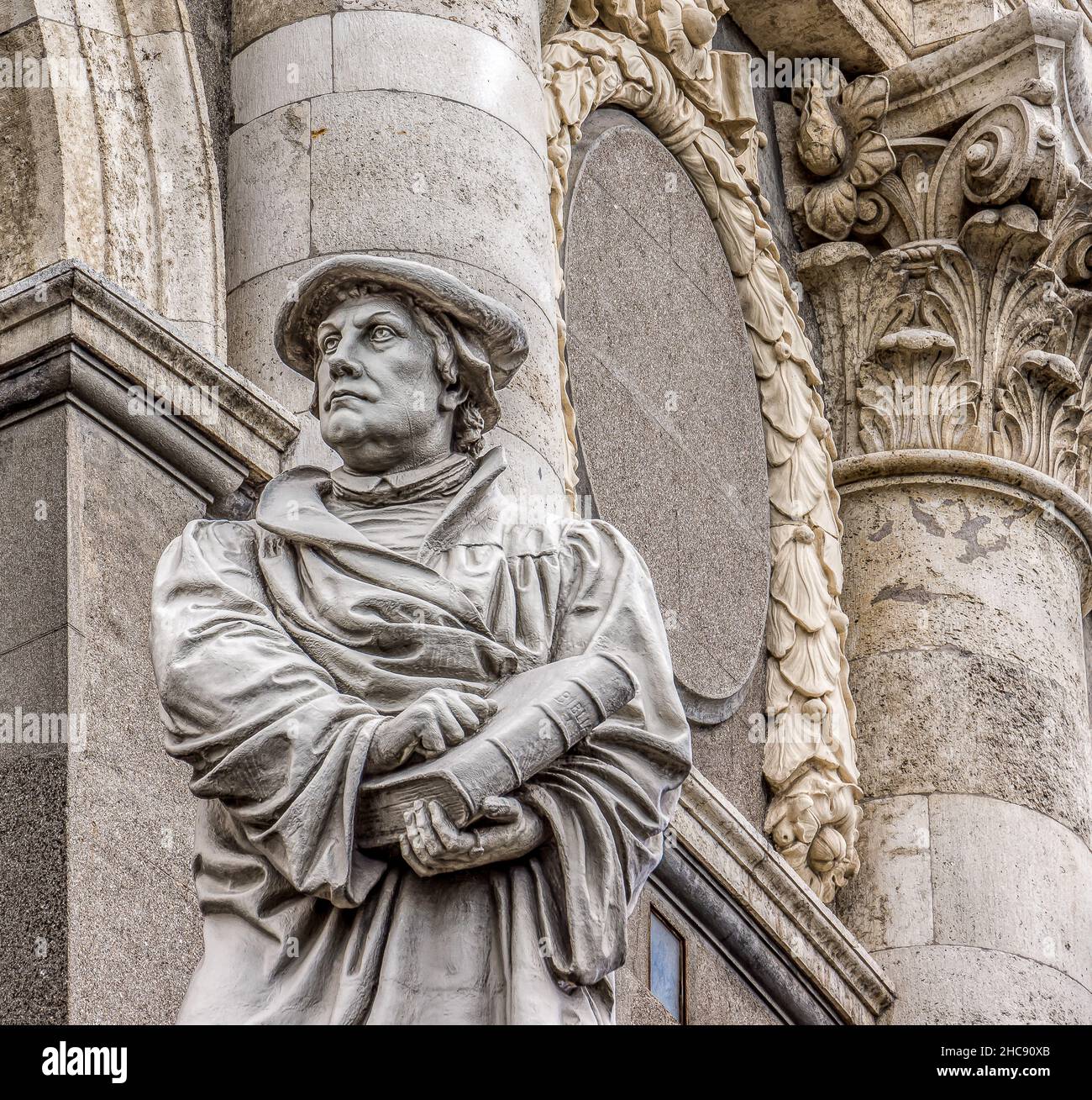 white statue of Martin Luther in baret holding a big bible in his hand in front of Marble church, Copenhagen, July 13, 2016 Stock Photo