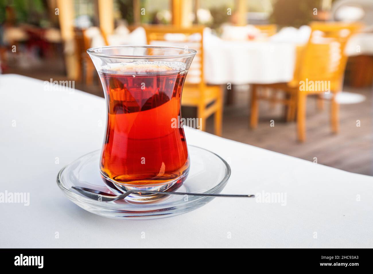 Glass of traditional Turkish or Azerbaijani strong tea on the table in a cafe or restaurant. A delicious drink for relaxation Stock Photo