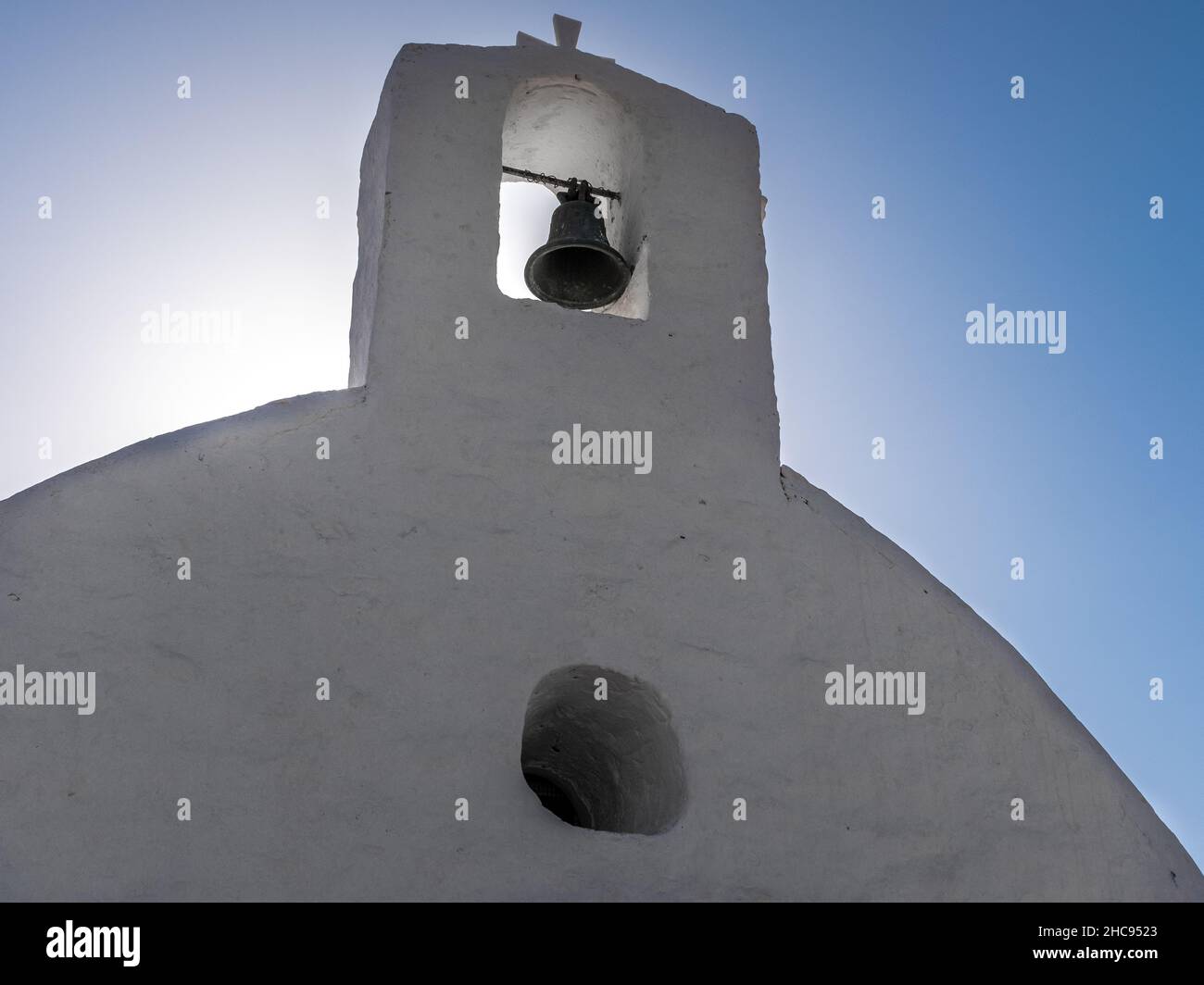 A traditional church steeple at sunrise in the Aegean Island of Ios, Greece, with blue sky and no people. Taken at the beginning of a perfectly sunny Stock Photo