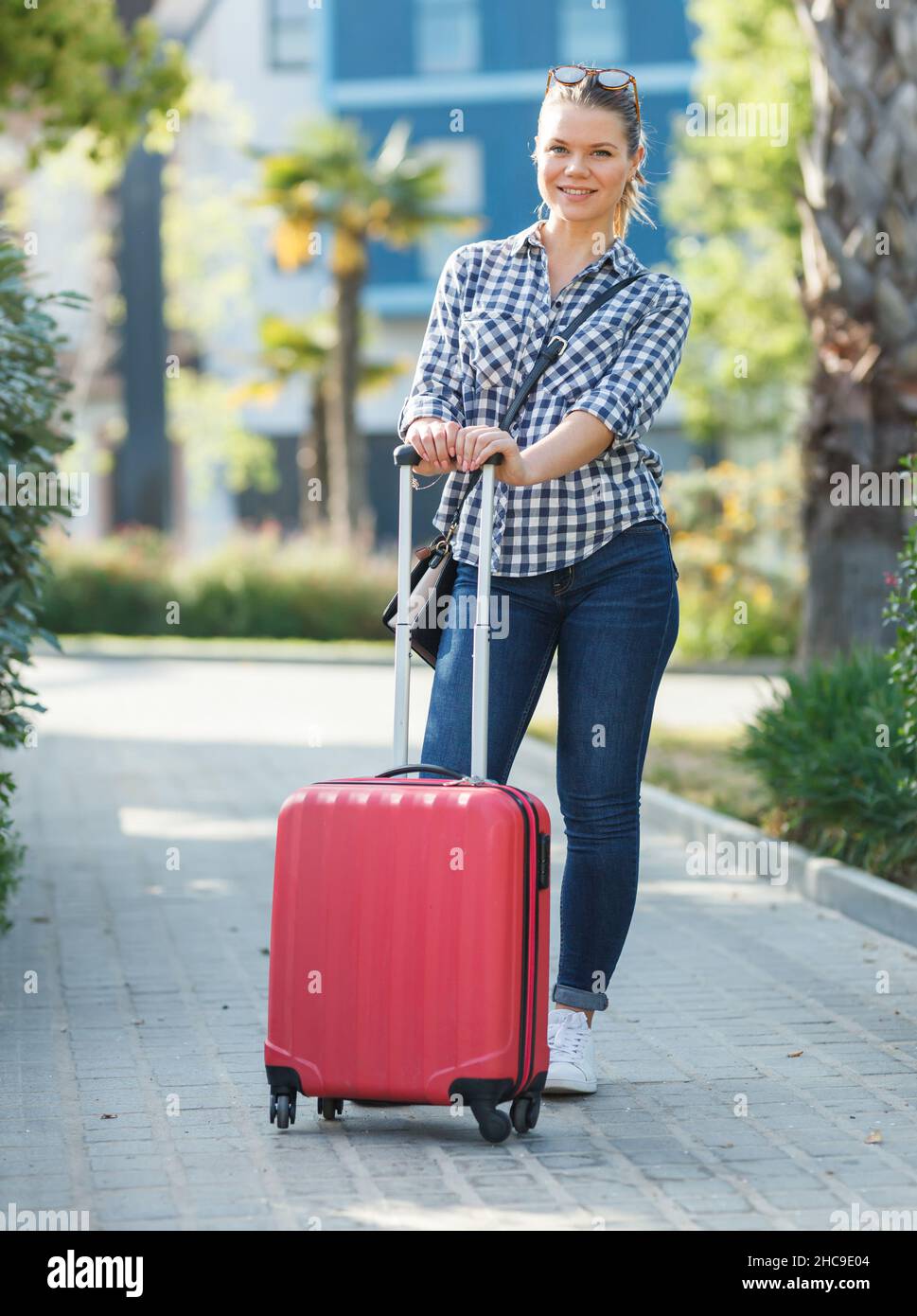 Girl carrying suitcase by streets Stock Photo Alamy