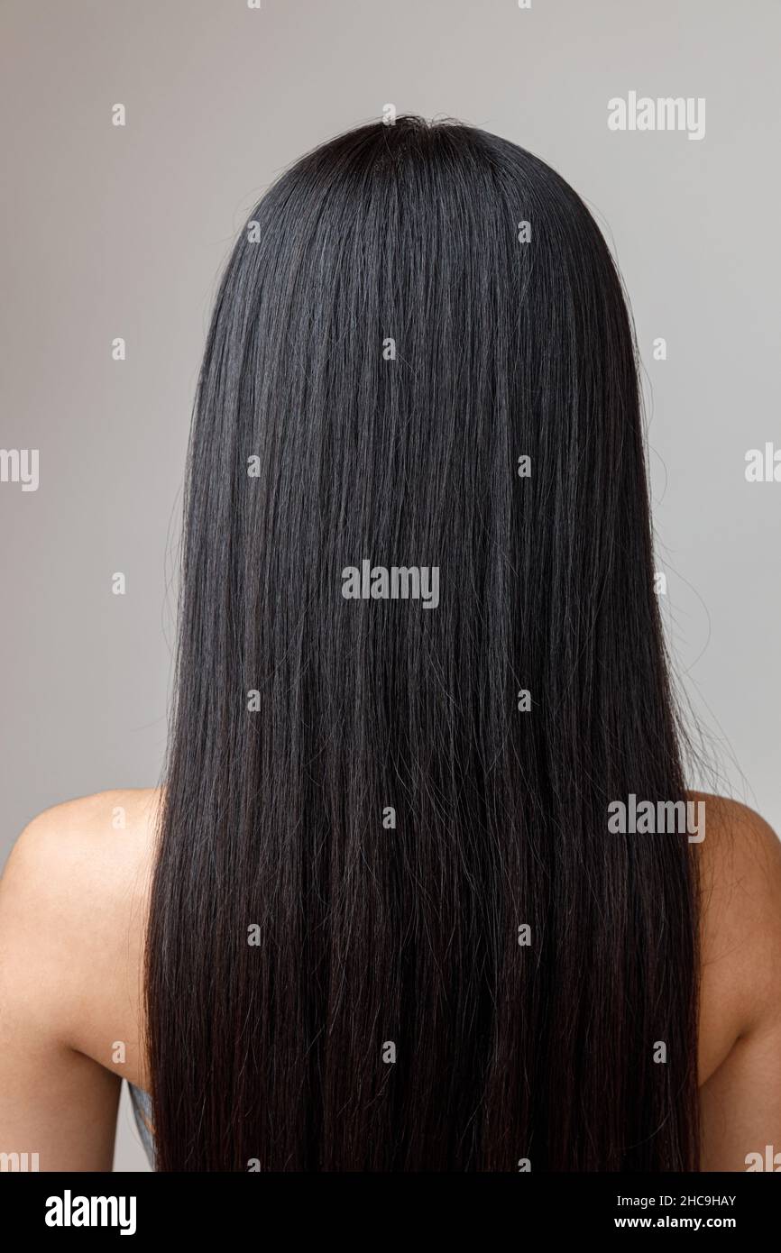 Brunette young woman with long hair standing in studio Stock Photo - Alamy