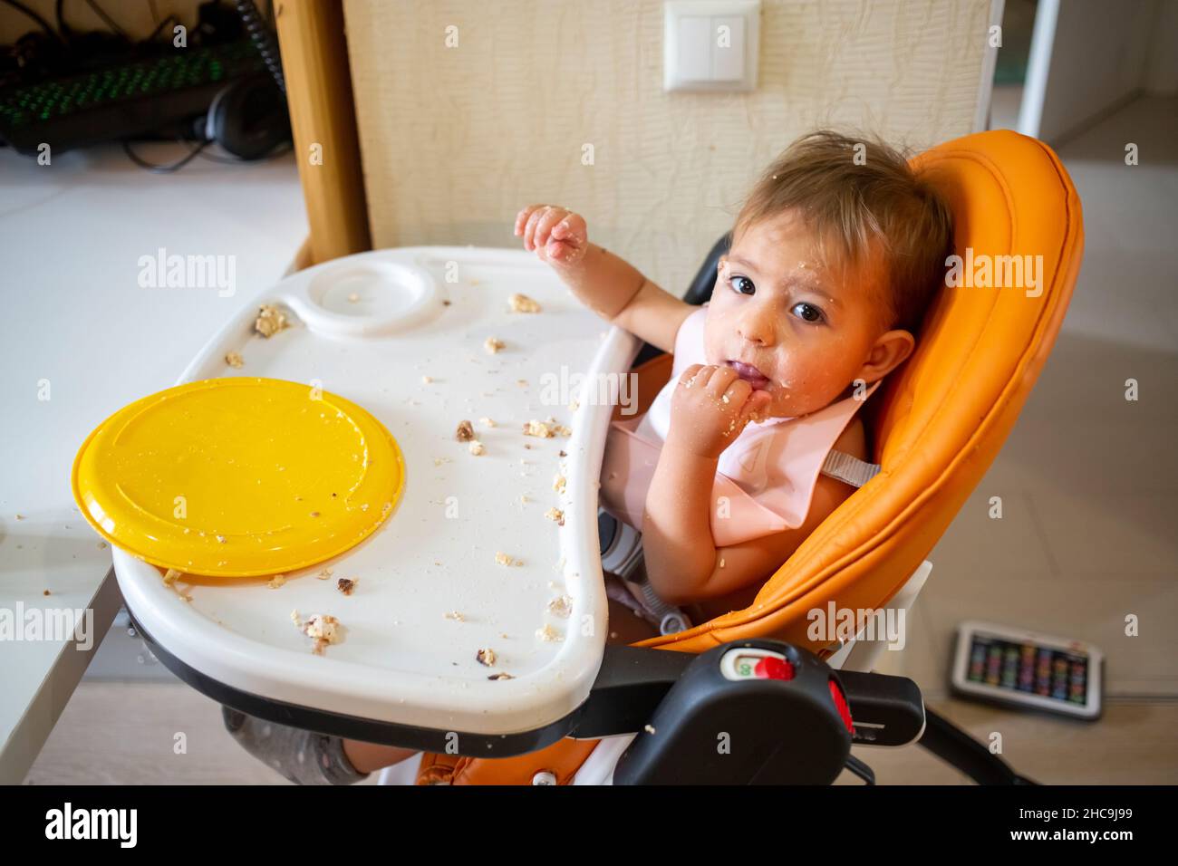 cute little infant baby eating in baby chair Stock Photo