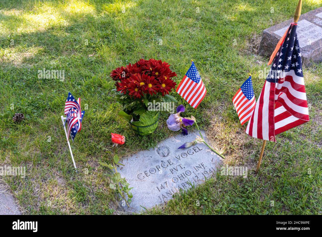 A small American flag and flowers decorate the grave of an veteran of ...