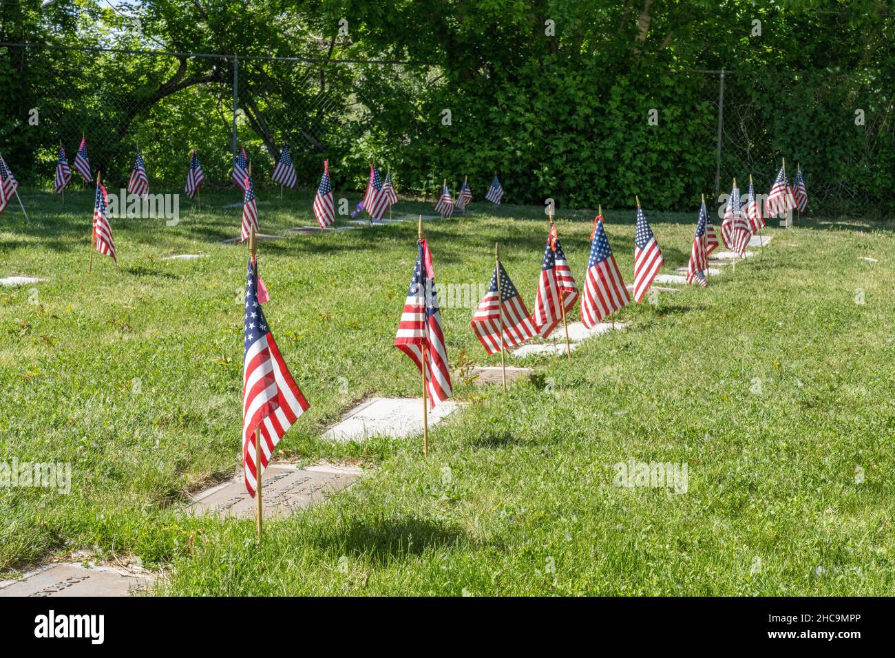 American flags decorate graves for the Memorial Day Holiday in the United States.  Memorial Day is an American holiday to remember the sacrifice of th Stock Photo