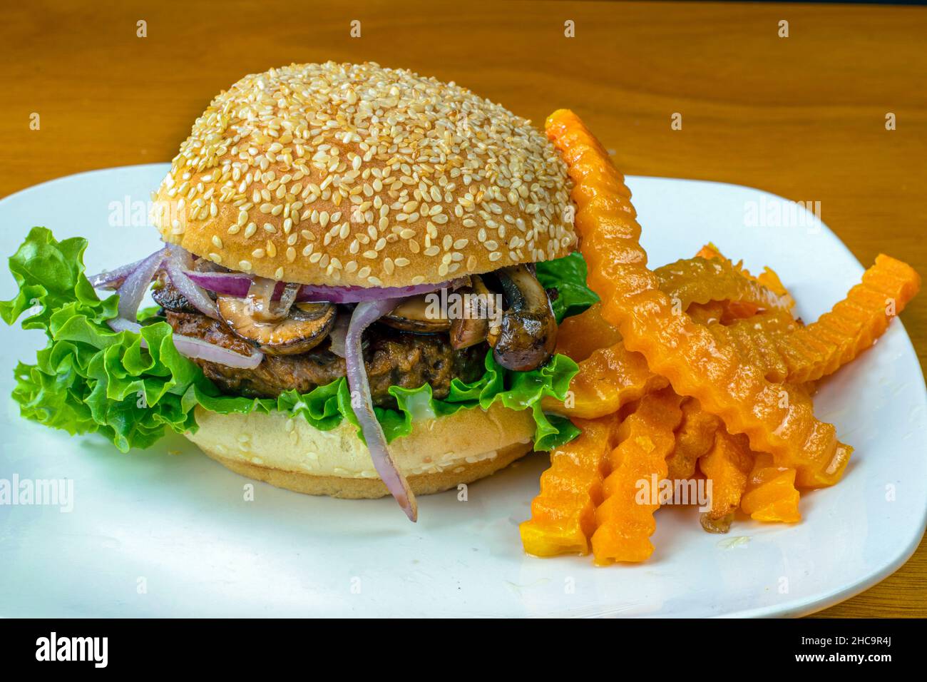 plant based hamburger top with sauteed mushrooms and onions, and