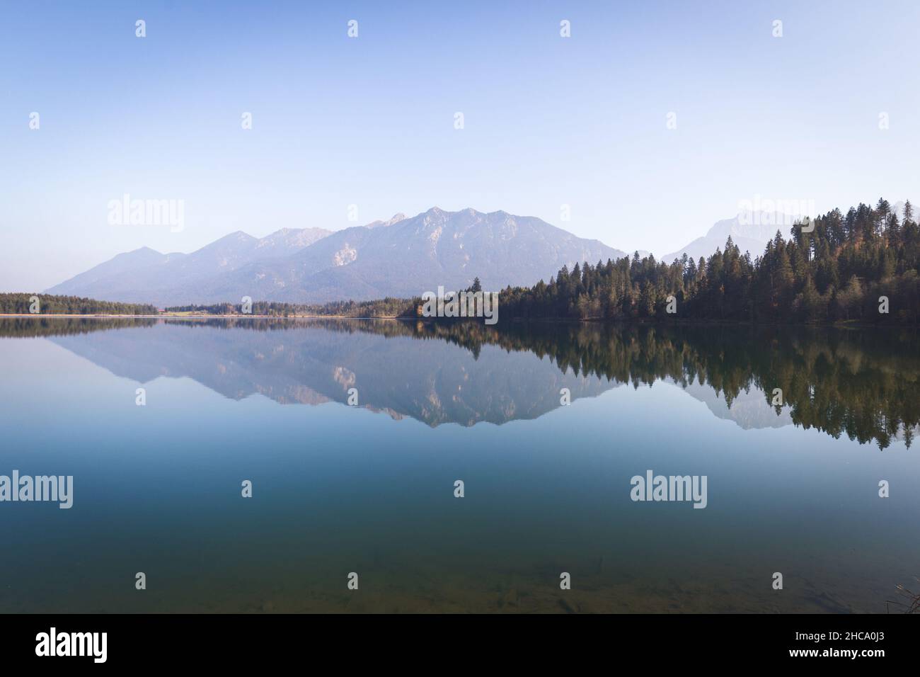 Beautiful view of a lake with the reflection of trees and mountains in ...