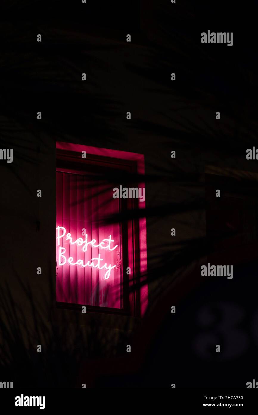 Vertical shot of a neon sign project beauty on the window stock photo