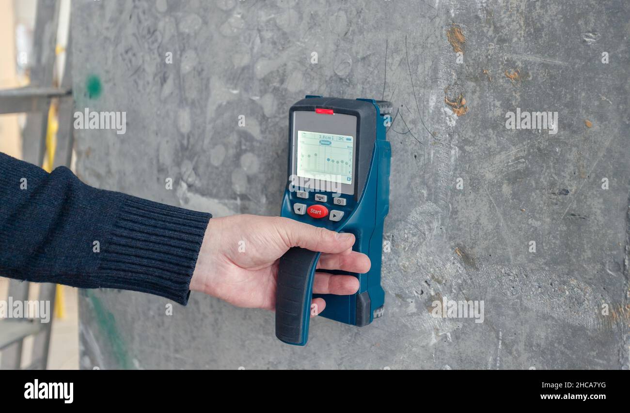 Inspection of the reliability of concrete structures. A device for ultrasonic examination of concrete, engineering background. Safe building concept. Stock Photo