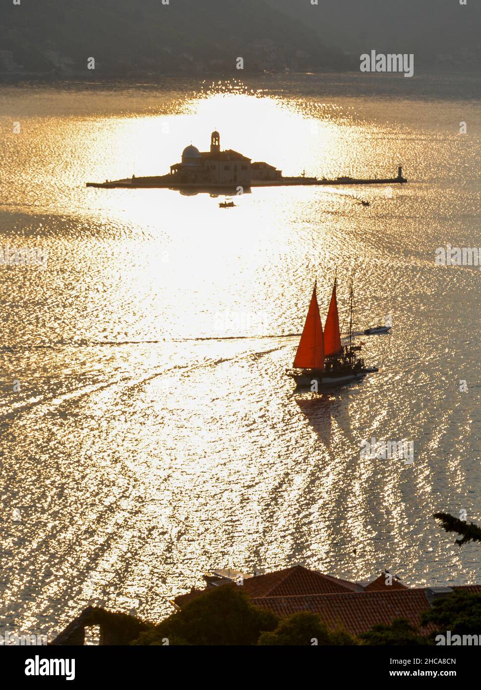 In the late summer sun, its sails glow in the backlight as it drifts by St Georges Island along the coast of this popular tourist destination. Stock Photo