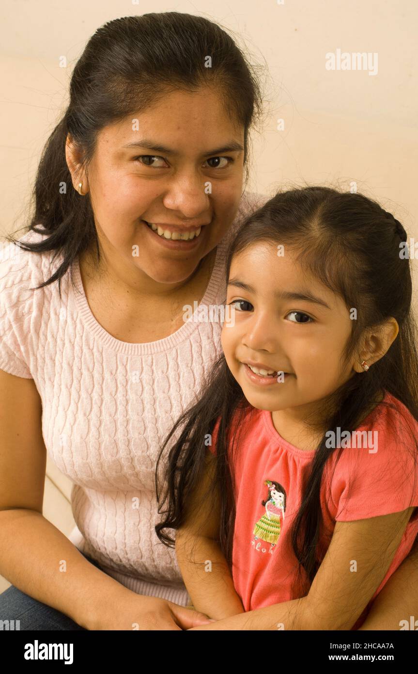 3 year old girl portrait with her mother Mexican American vertical Stock Photo