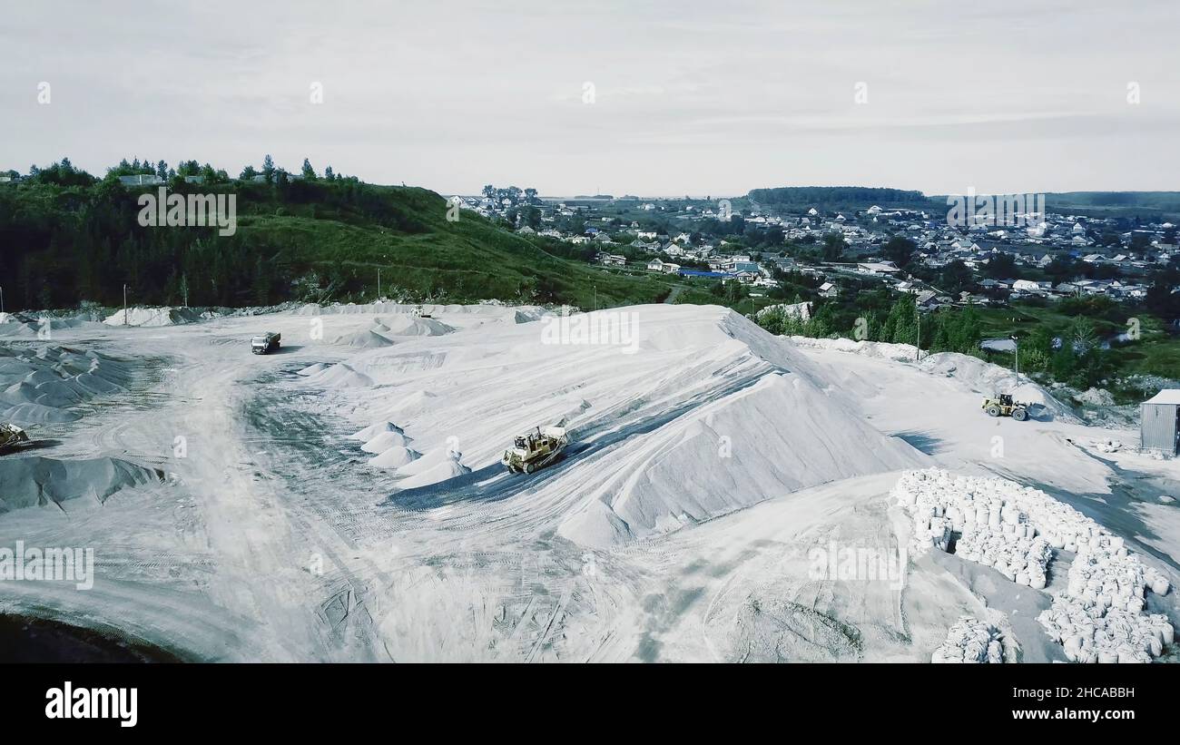 Aerial view of opencast mining quarry with lots of machinery at work ...