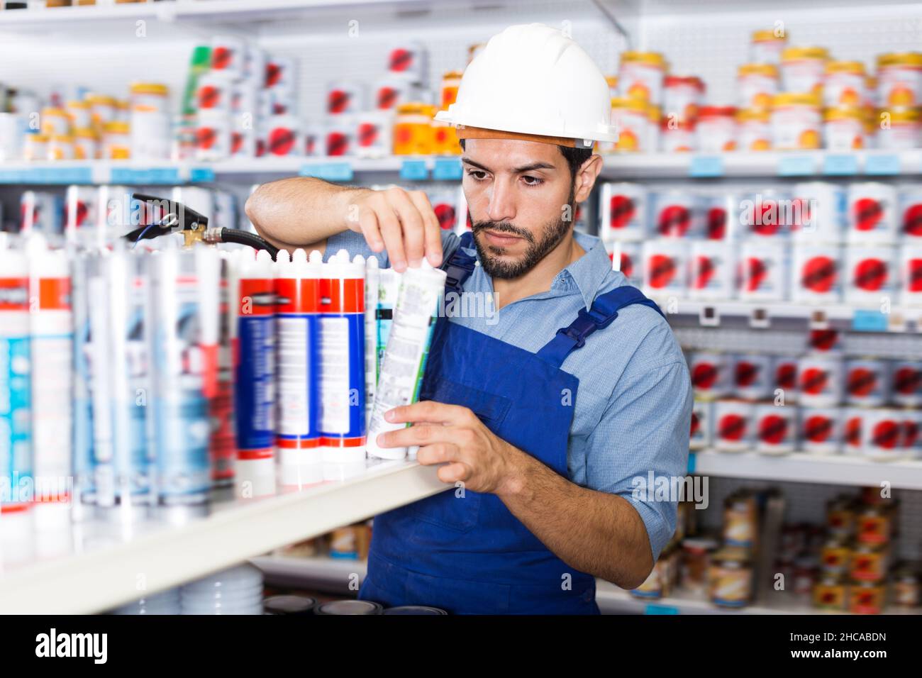 Concentrated young handyman choosing materials Stock Photo