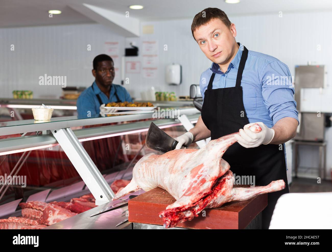butcher cutting lamb carcass in butcher shop Stock Photo Alamy