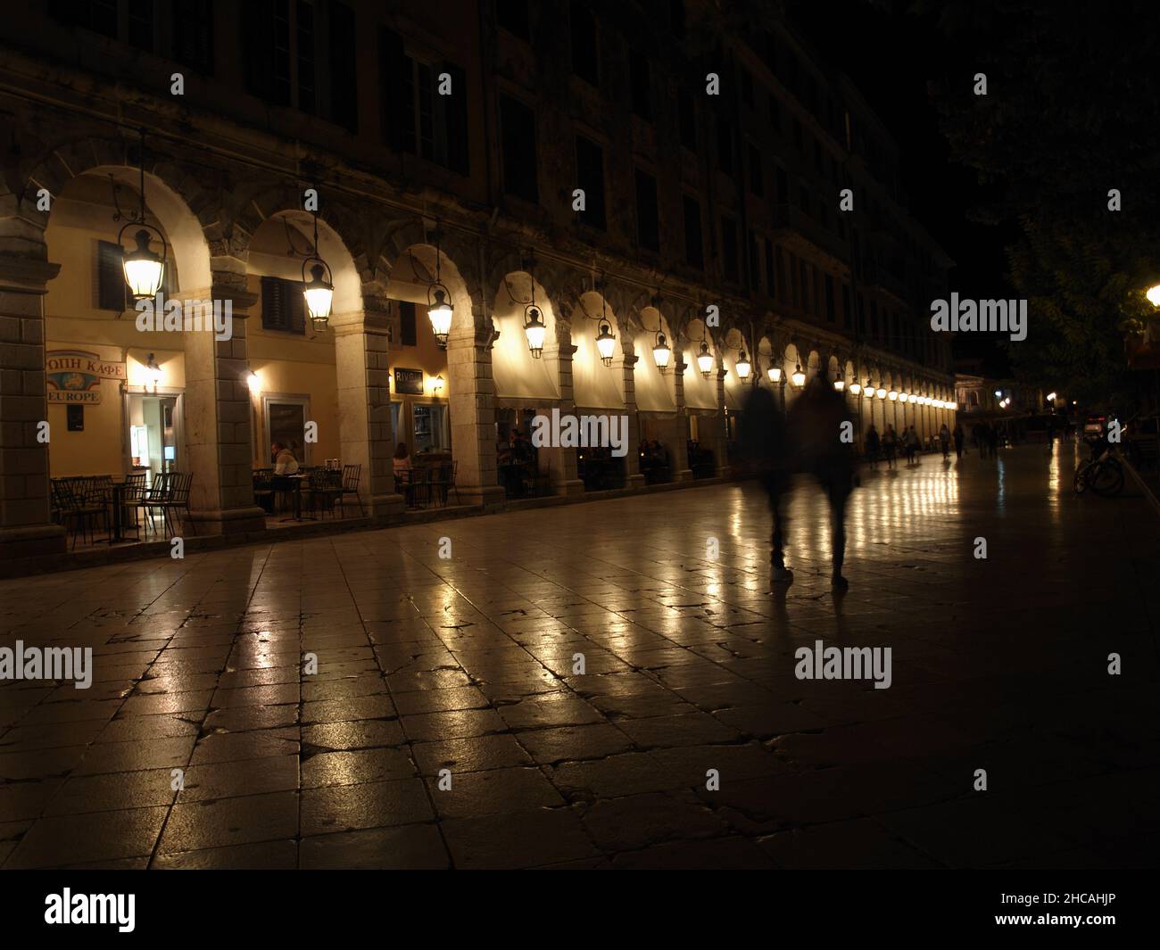 Lights reflecting on pavement at night time at The Liston; Corfu Town, Greece Stock Photo