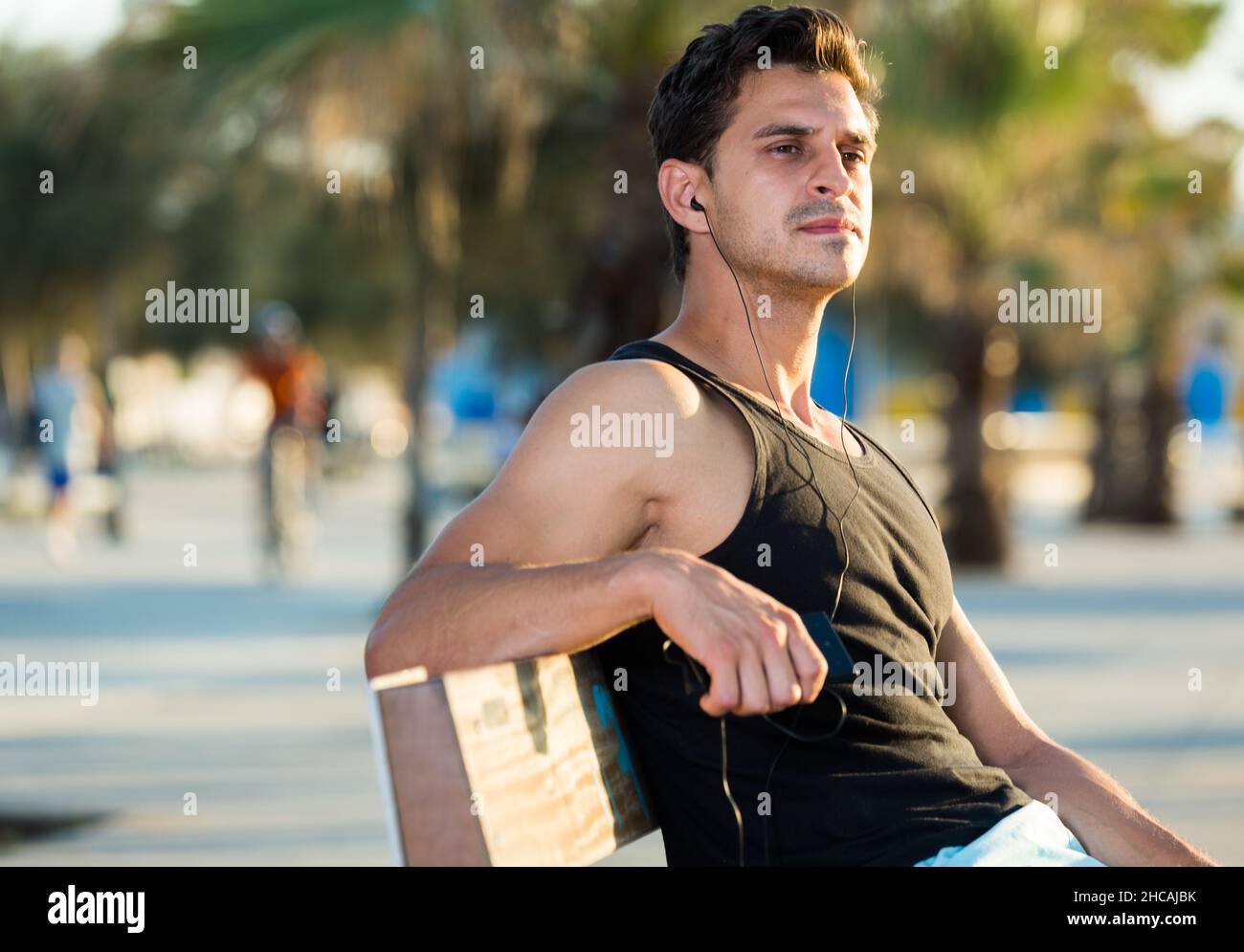 Sporty man resting on bench after workout Stock Photo