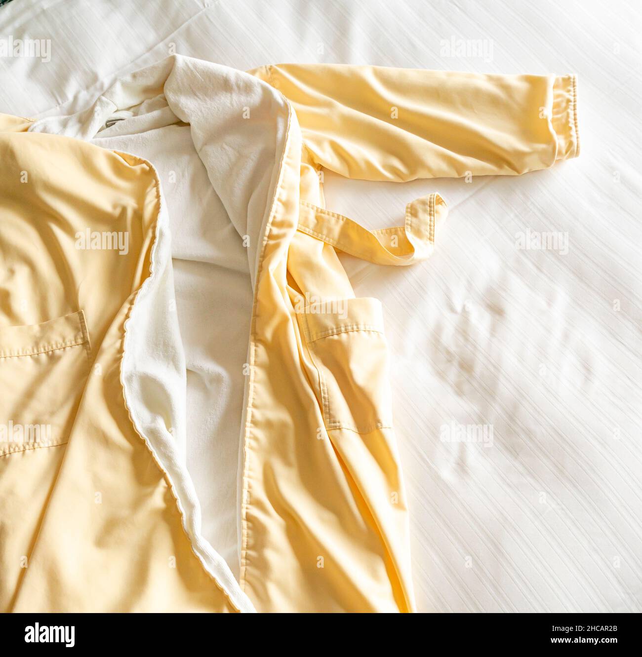 Bath robe on the white sheets on the bed Stock Photo Alamy