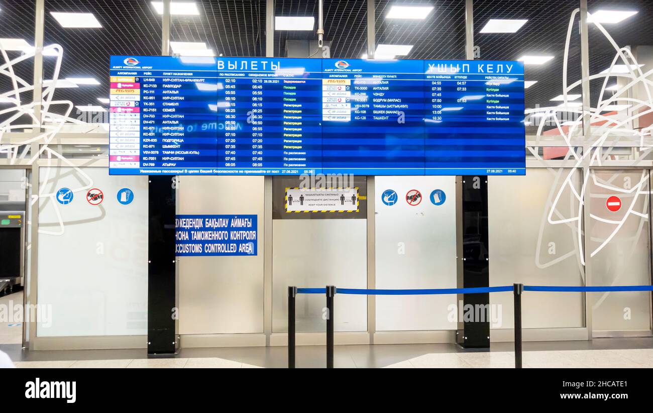 Departures information display with flights information in Almaty airport, Kazakhstan Stock Photo