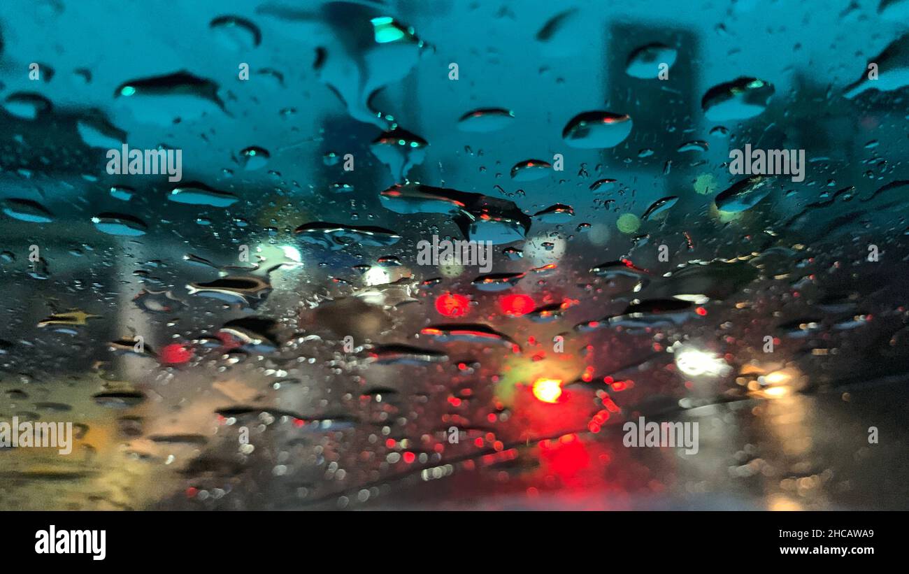 Raindrops at the windshield with red dark background Stock Photo