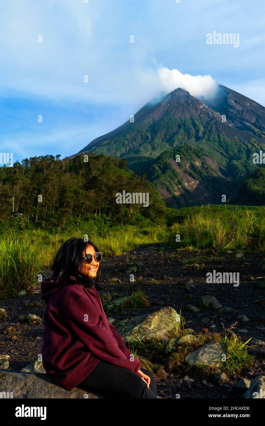 Young girl sitting with the volcano in the background. Stock Photo