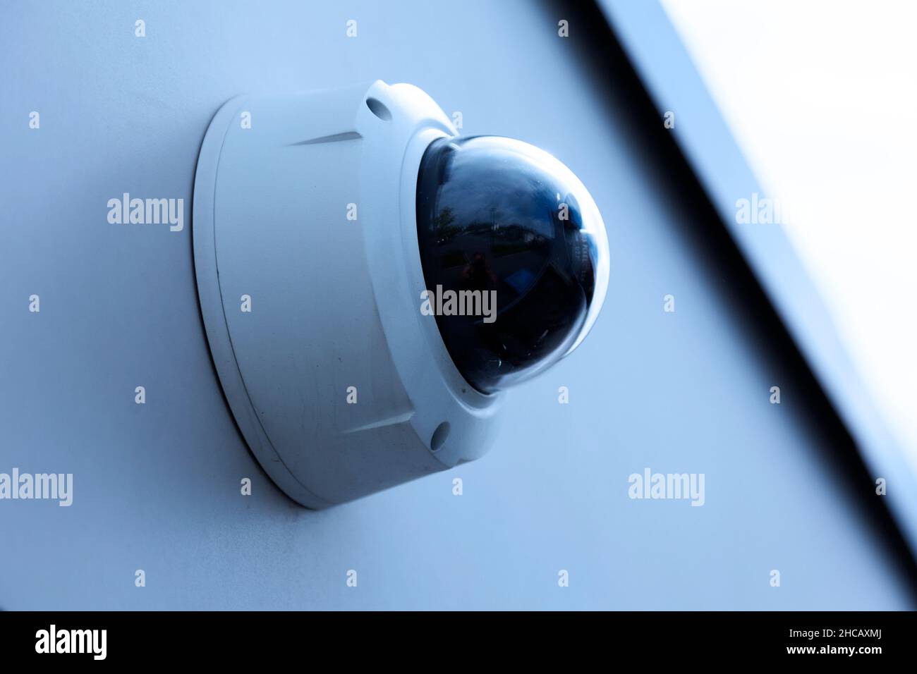 surveillance camera mounted on a wall outdoors Stock Photo