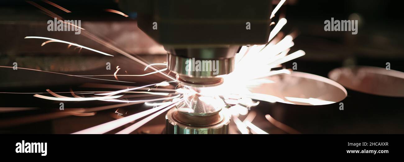 Laser cutting of metal sheet with sparks closeup Stock Photo