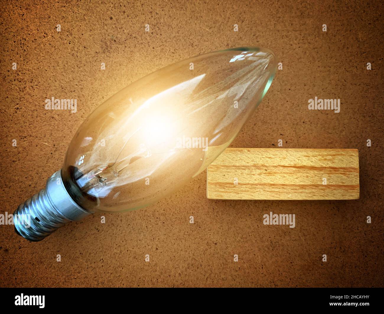 A block of wood with a shining bulb Stock Photo - Alamy
