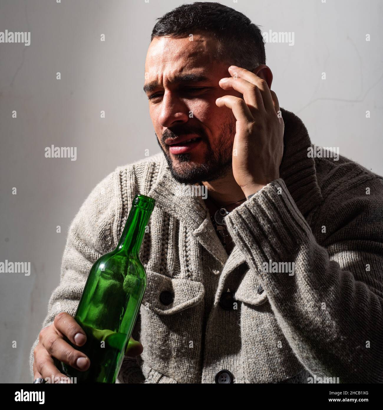 Alcoholic man with bottles wine cry. Depressed crying man. Drunk men drinking alcohol feeling