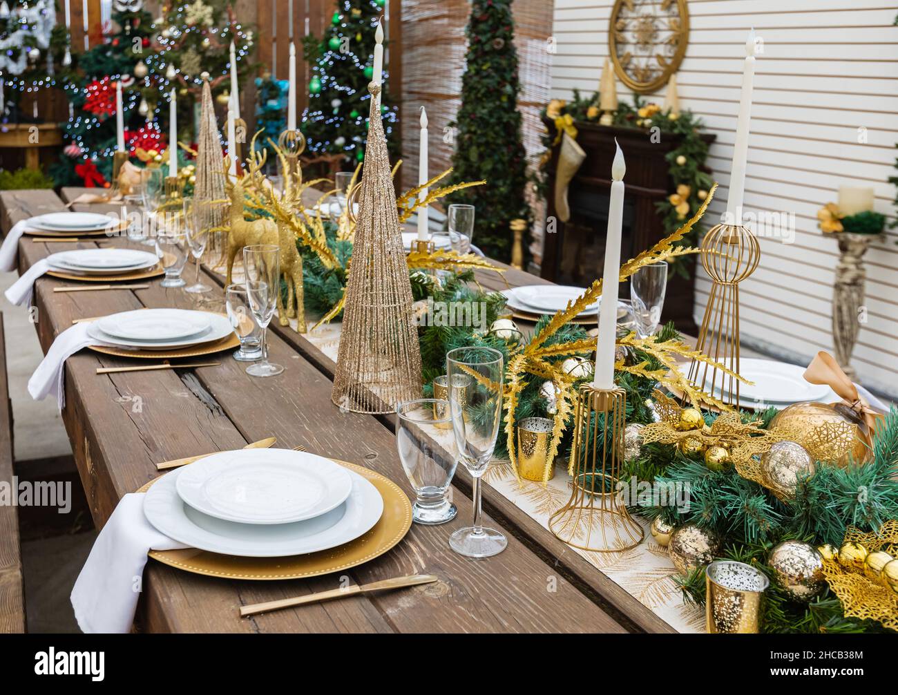 Rustic christmas served table. Table served for Christmas dinner in living room. Christmas table setting with festive decorations. Nobody, selective f Stock Photo