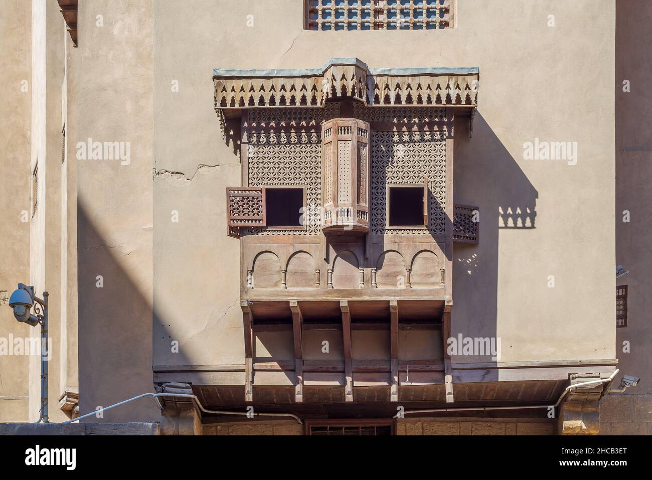 Mamluk era style oriel window covered by interleaved wooden grid - Mashrabiya, on shabby grunge external wall, at historical House of Egyptian Architecture, old Cairo, Egypt Stock Photo