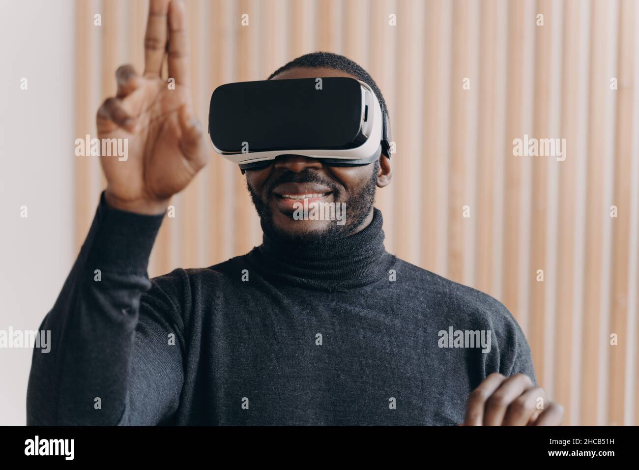 Excited African American man in VR headset glasses enjoying augmented ...