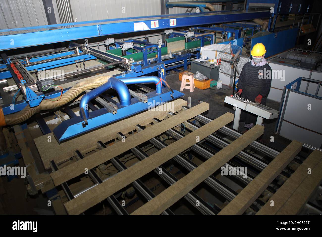 CHONGQING, CHINA - DECEMBER 27, 2021 - After automatic cutting, rockwool slivers are pushed into the production line in a fixed number of programmed g Stock Photo