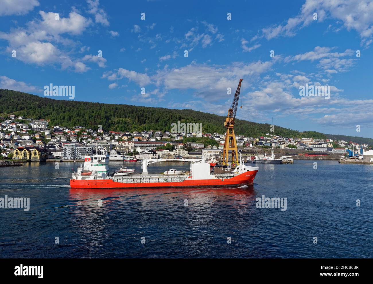 The Kristian With, a General Cargo Vessel departing from Bergen Port through the calm waters of the Fjord on a bright Summers morning. Stock Photo