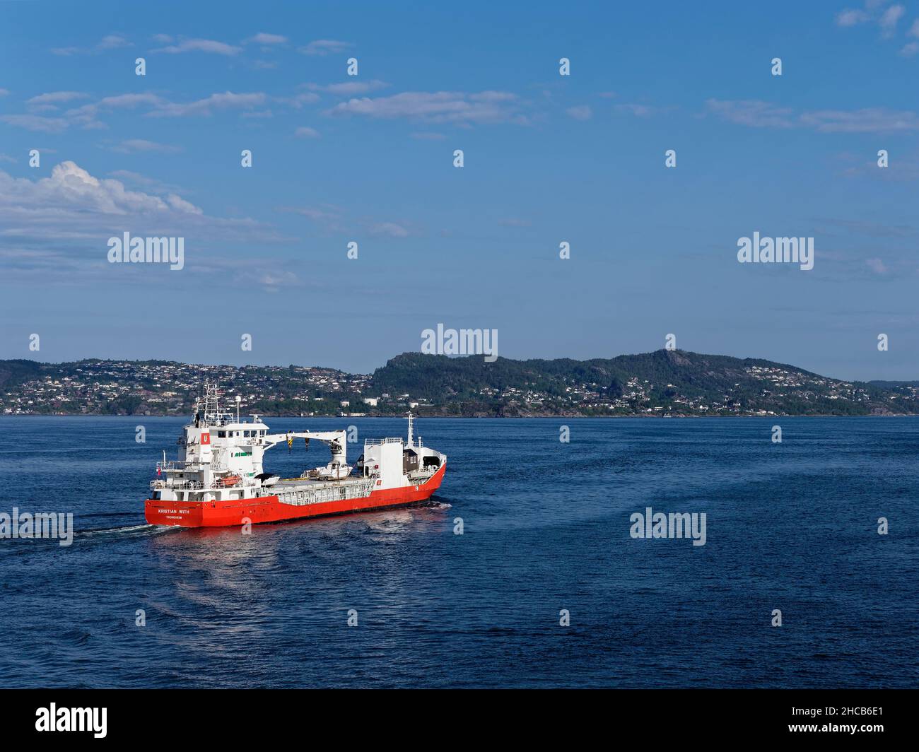 The Kristian With, a General Cargo Vessel in Bergen Fjord heading out to the North Sea in calm water with surface currents visible. Stock Photo