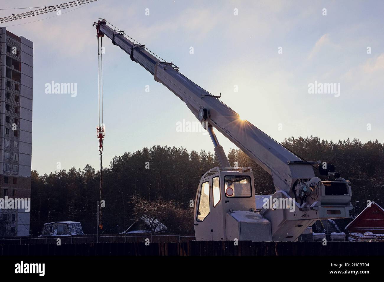 Auto crane at construction site. Equipment for lifting heavy loads on a