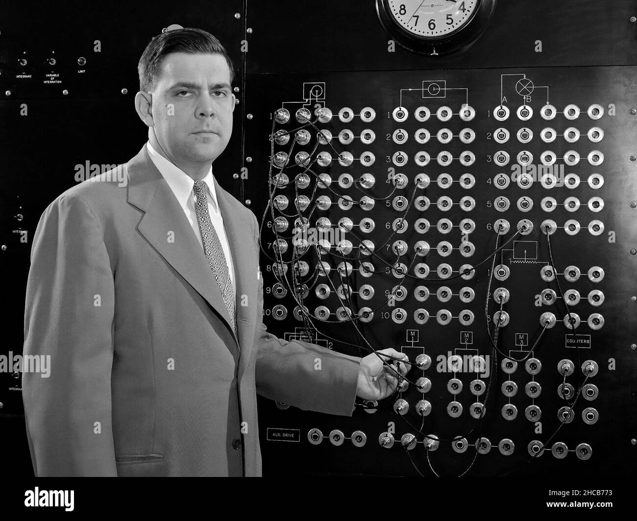 Harry Mergler stands at the control board of a differential analyzer in the new Instrument Research Laboratory at the National Advisory Committee for Aeronautics (NACA) Lewis Flight Propulsion Laboratory. The differential analyzer was a multi-variable analog computation machine devised in 1931 by Massachusetts Institute of Technology researcher and future NACA Committee member Vannevar Bush. The mechanical device could solve computations up to the sixth order, but had to be rewired before each new computation. Mergler modified Bush’s differential analyzer in the late 1940s to calculate droplet Stock Photo