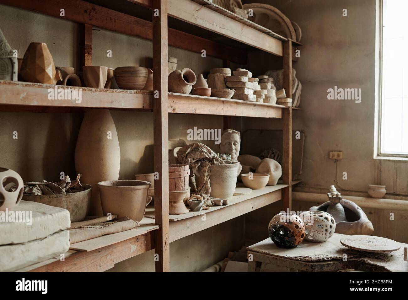 Image of different ceramic vases on the shelves in the workshop Stock Photo