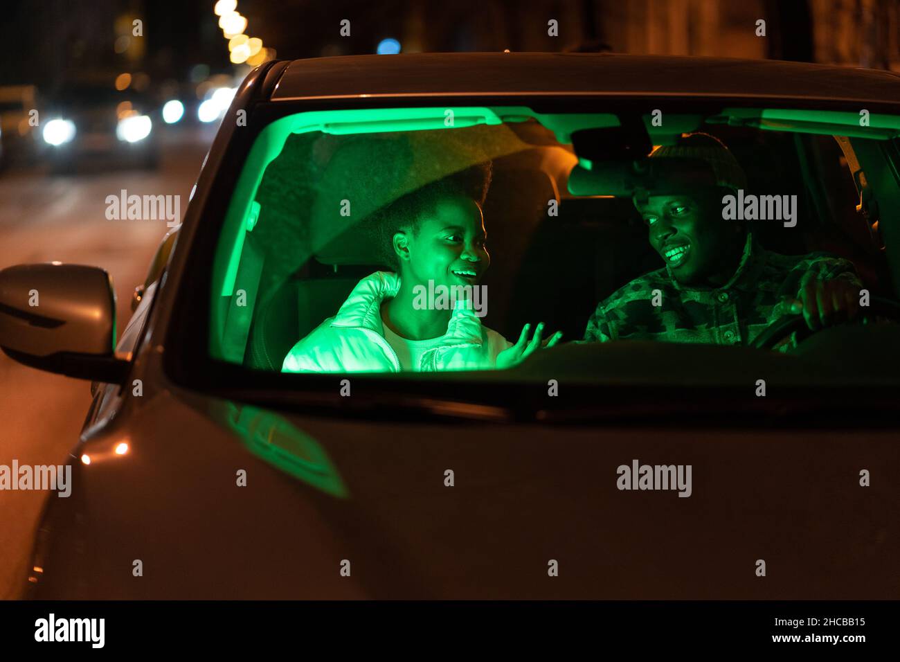 Happy couple in love talk inside car. Man and woman romantic lovers communicate at night after date Stock Photo