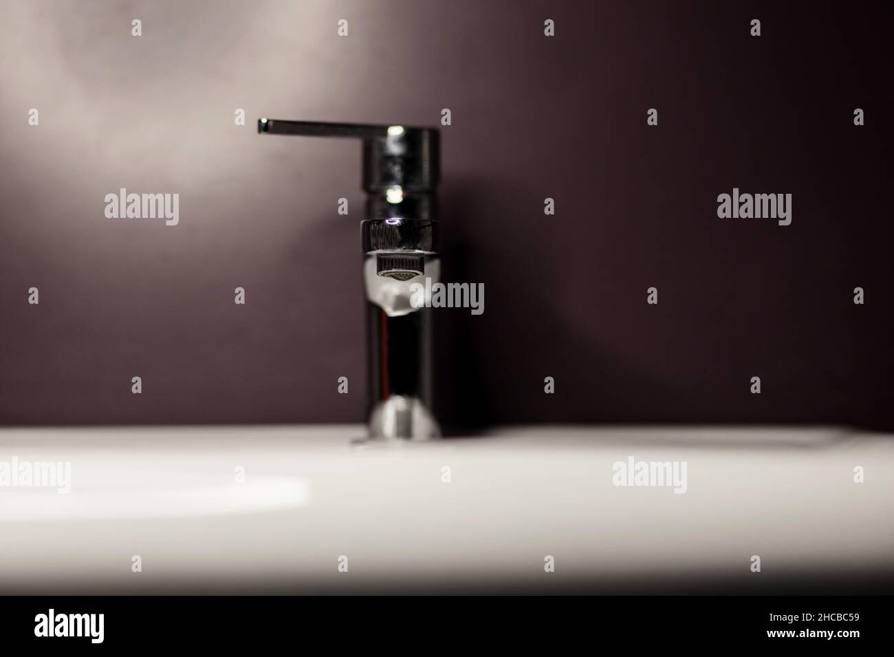 Metal faucet in the bathroom without water. Steel water tap Stock Photo