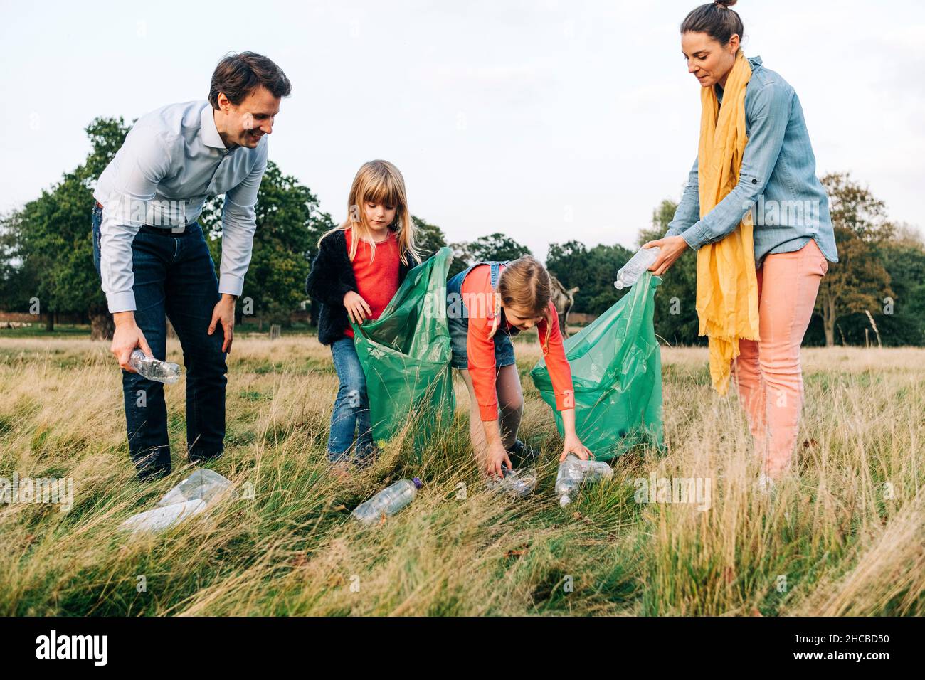 Family collecting plastic bottles after picnic in park Stock Photo Alamy