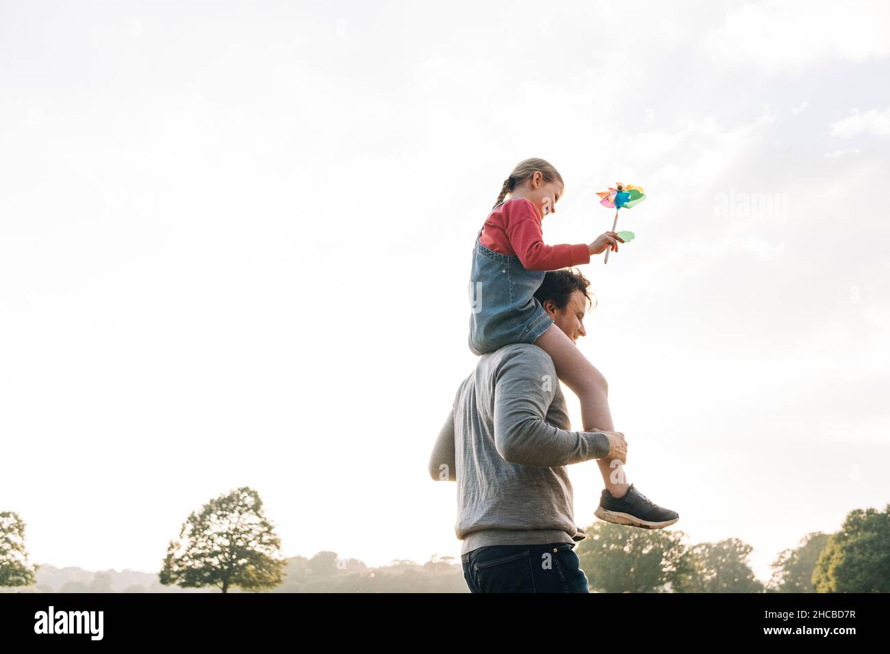 Father carrying daughter on shoulders in park Stock Photo - Alamy