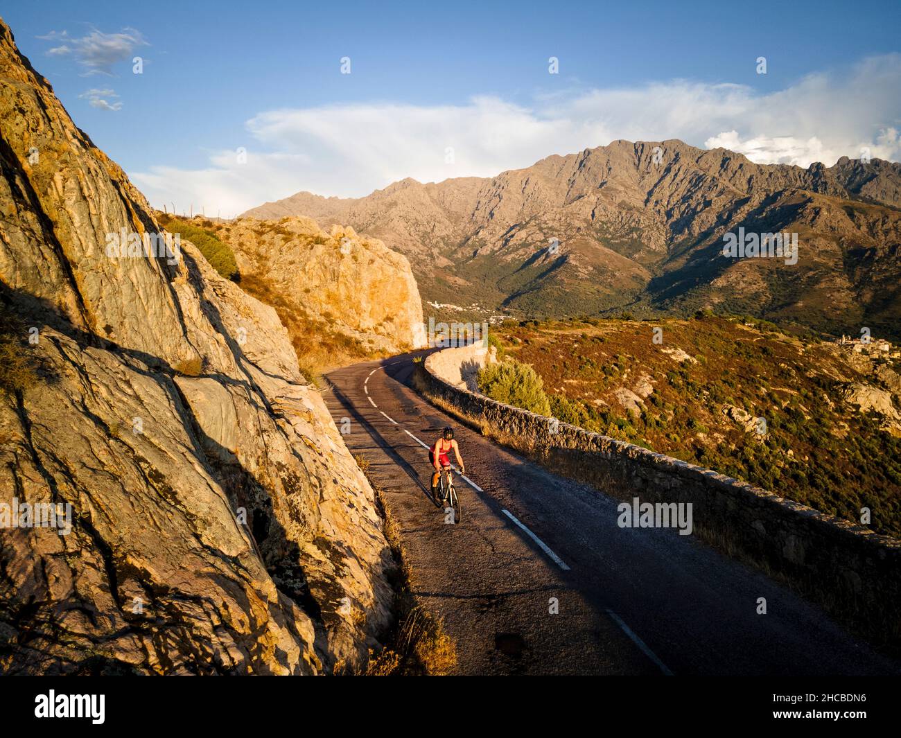 Sportswoman cycling on road by mountain Stock Photo
